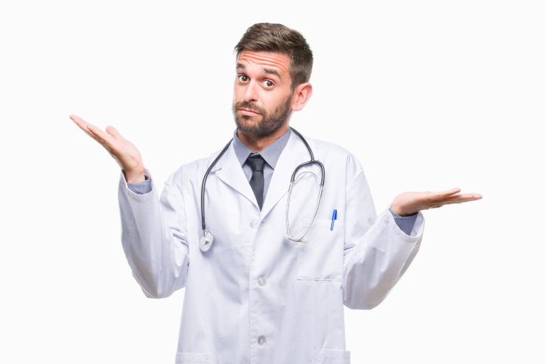 Young handsome doctor man over isolated background clueless and confused expression with arms and hands raised. Doubt concept.