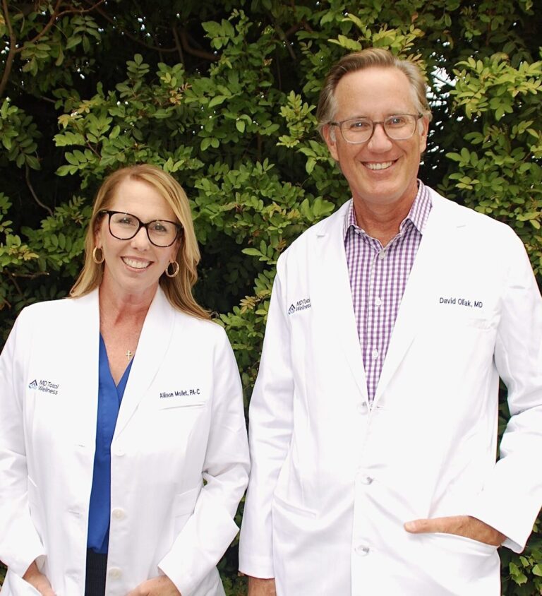 a man (Dave) and woman (Allie) wearing white lab coats