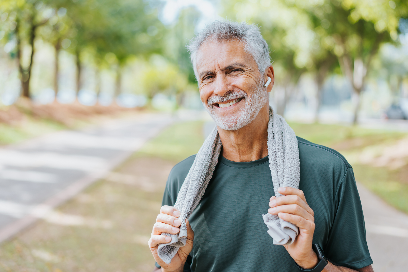 Senior man runner holding towel around neck
