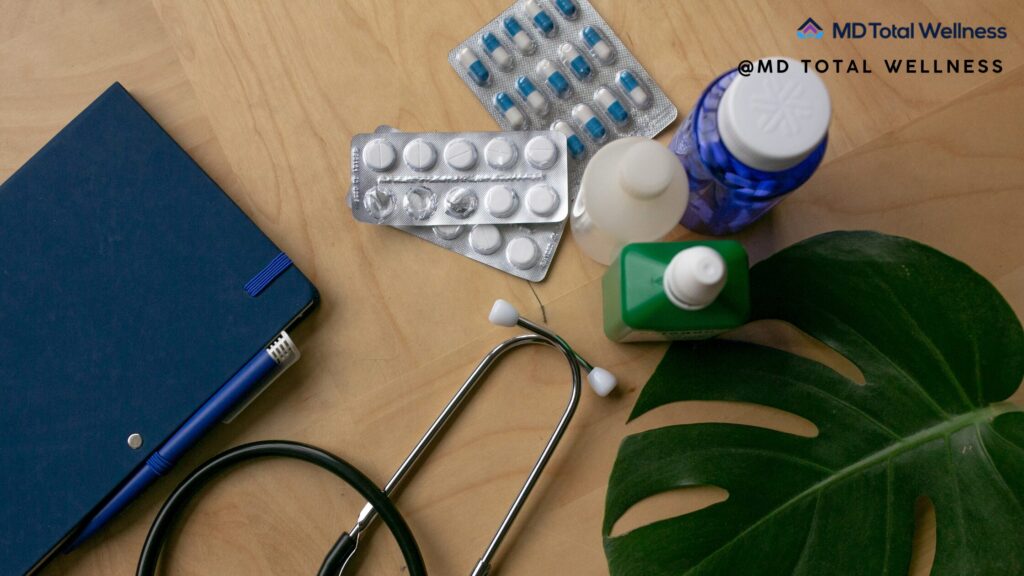 Medical supplies including stethoscope, pill bottles, blister packs, notebook and green plant for whole-body health OC.